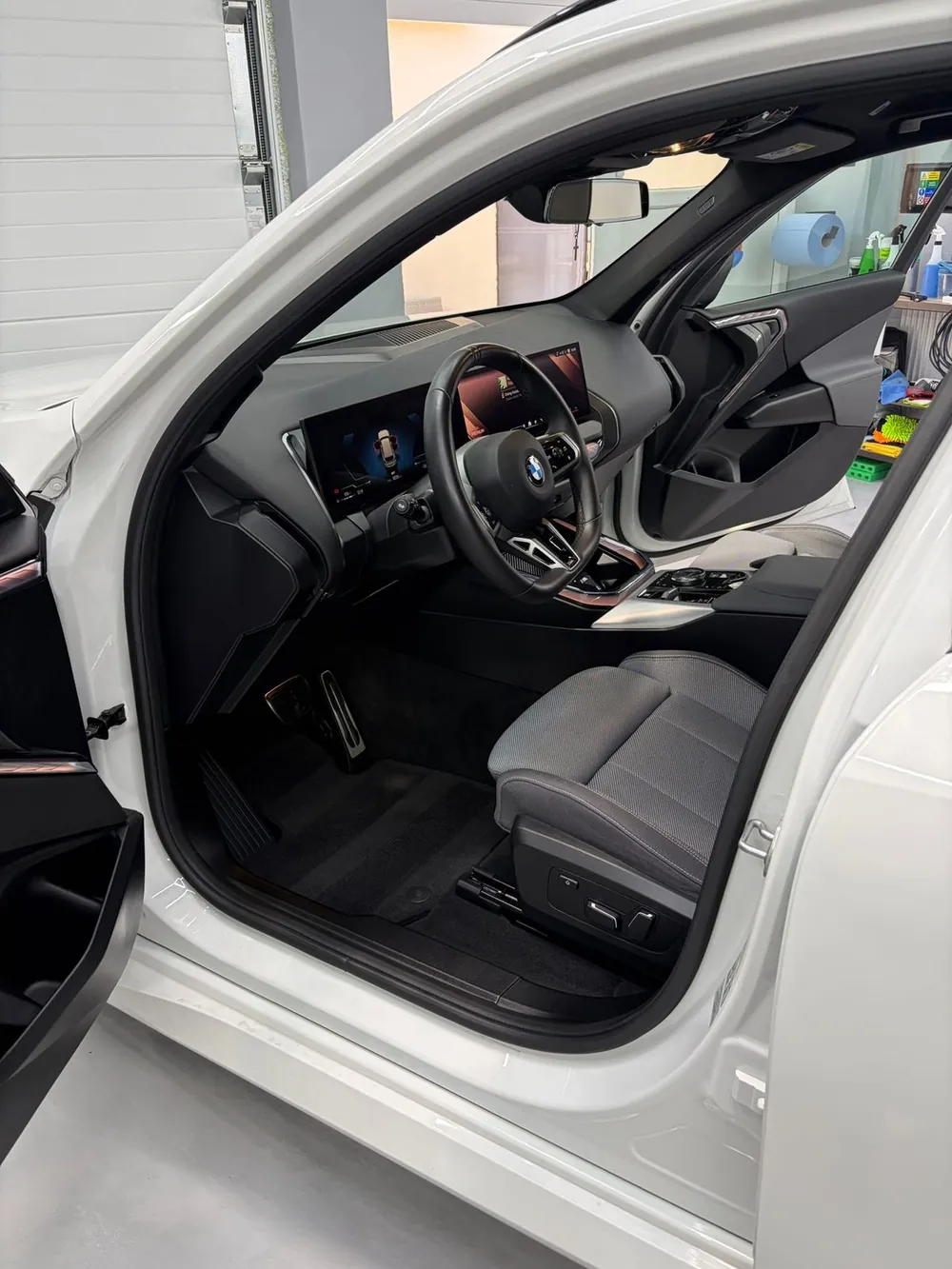 Priestor vodiča BMW X3 po detailingu interiéru — čisté koberce, koža a ošetrené plasty